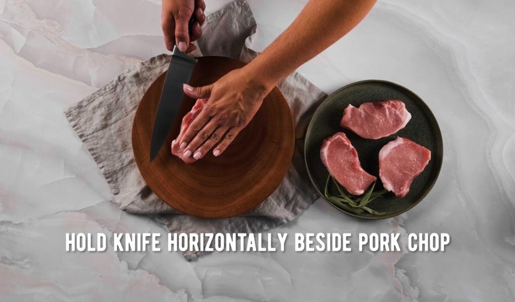 Step 1 to butterflying a pork chop - hold knife horizontal